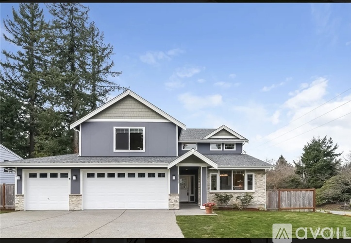 A two-story house with a garage is for sale.