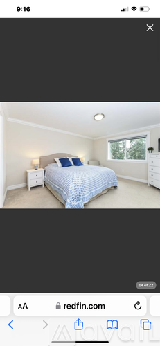 A bedroom with a bed, nightstand, and window.