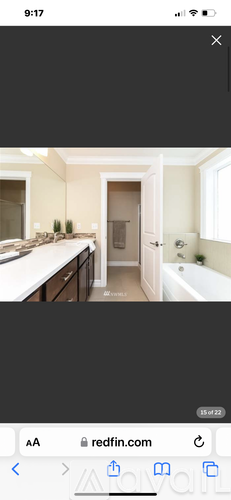 A bathroom with a tub, sink, and mirror.