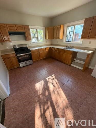 A kitchen with brown cabinets and a tiled floor.