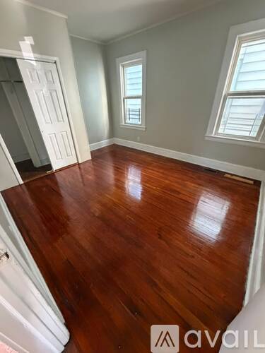 A room with wooden flooring and a window.