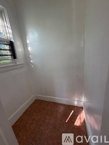 A room with a window and a tiled floor.