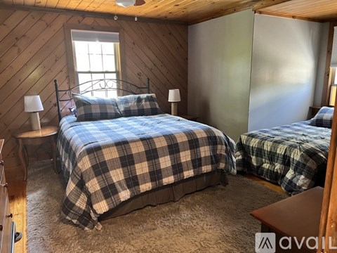 A bedroom with two beds and a window.