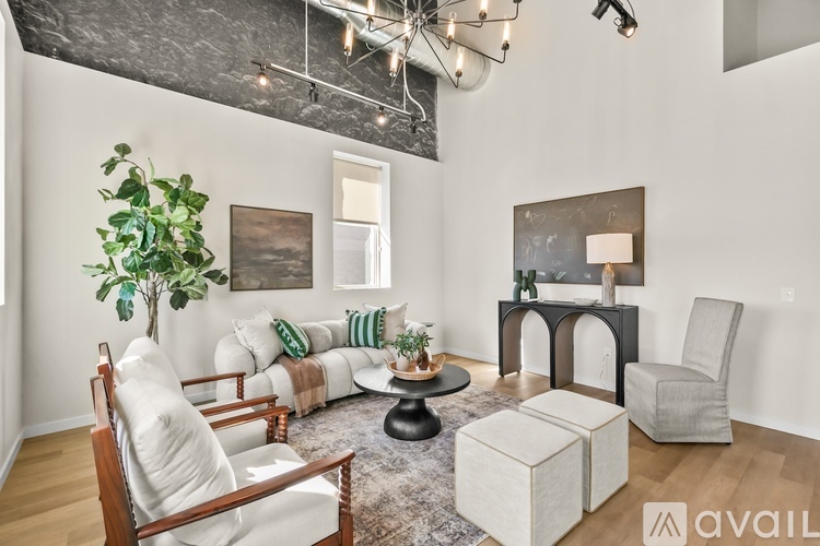A living room with a white couch, a wooden chair, and a grey armchair.