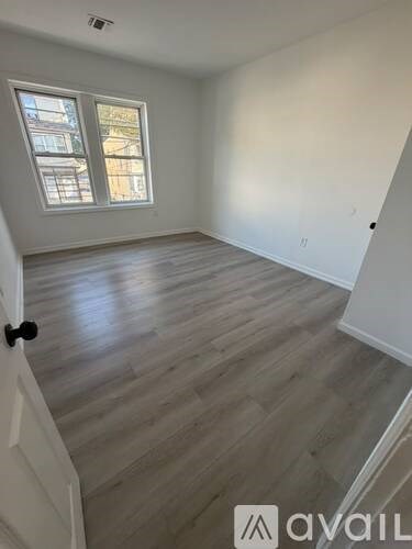 A room with wooden flooring and a window.