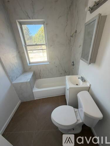 A bathroom with a toilet, sink, and bathtub.
