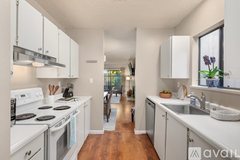A kitchen with white cabinets and a stove top oven.