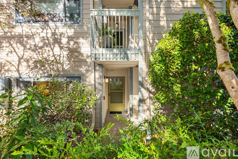 A balcony with a metal railing is on the second floor of a building.