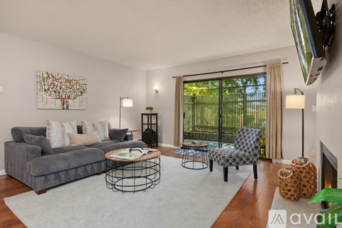 A living room with a grey couch, a coffee table, and a painting on the wall.