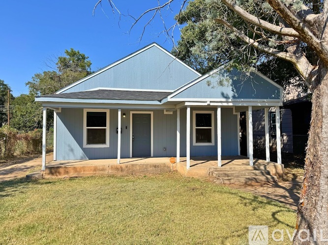 A blue house with white columns and a porch.
