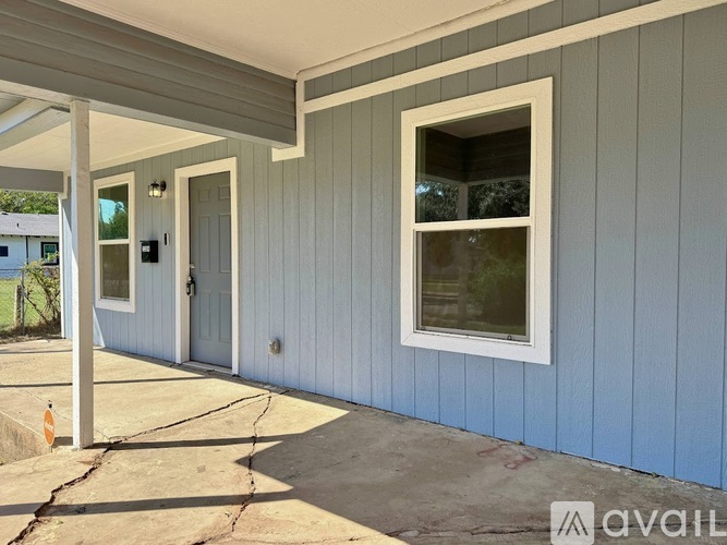 A house with a blue siding and a white door is for sale.