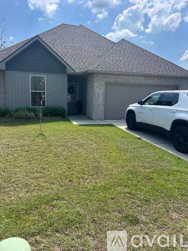 A white SUV is parked in front of a house with a garage.