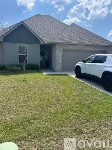 A white SUV is parked in front of a house with a garage.