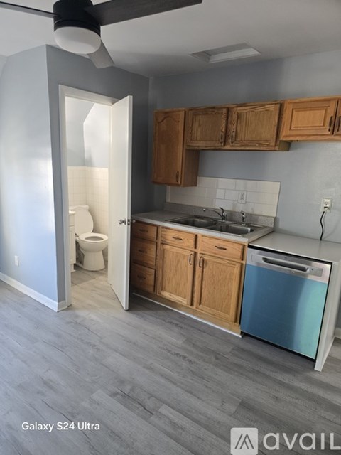 A kitchen with wooden cabinets and a blue dishwasher.
