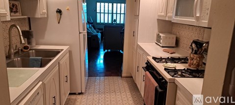 A kitchen with white cabinets and a black stove top oven.