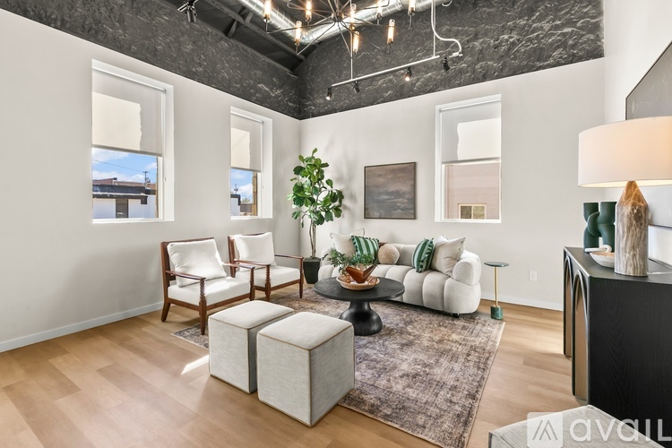 A living room with a couch, chairs, and a rug.