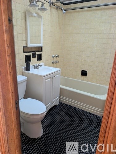 A bathroom with a toilet, sink, and bathtub.
