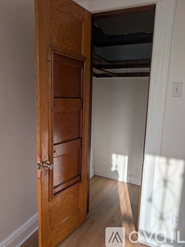 A wooden door with a handle and a lock is open.