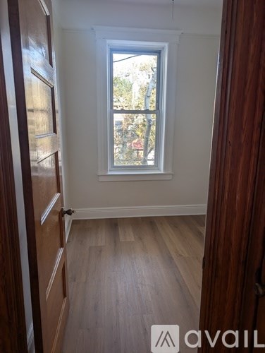 A room with a window and wooden floors.