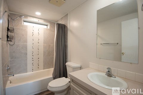 A bathroom with a white tub, toilet, and sink.