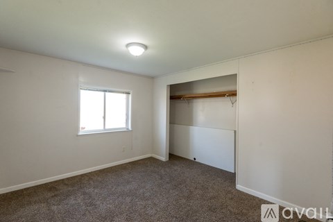 A room with a window and a closet.