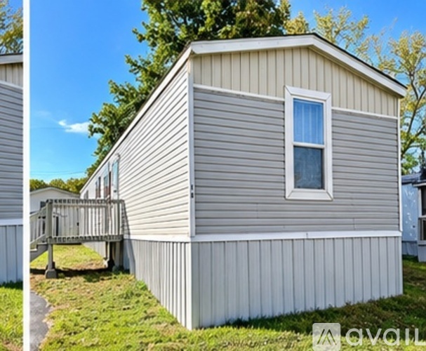 A beige mobile home with a white window and a deck.