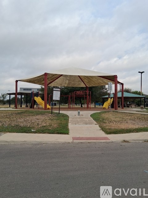 A covered walkway leads to a building with a yellow slide.