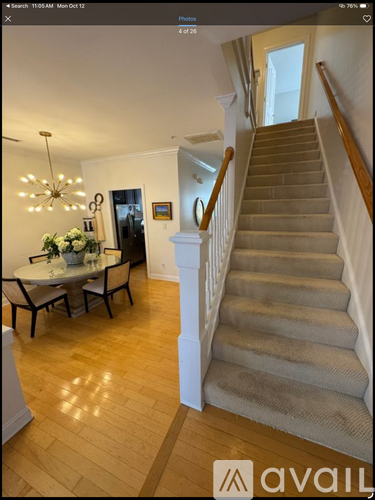 A staircase with a beige carpet and wooden banister.