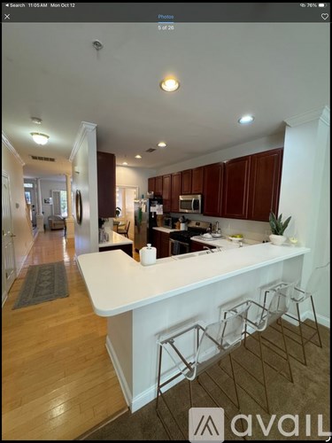 A kitchen with a white island and brown cabinets.