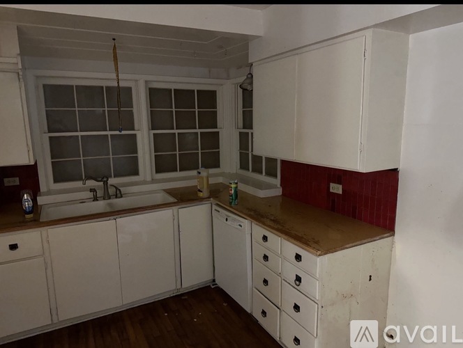A kitchen with white cabinets and a sink.