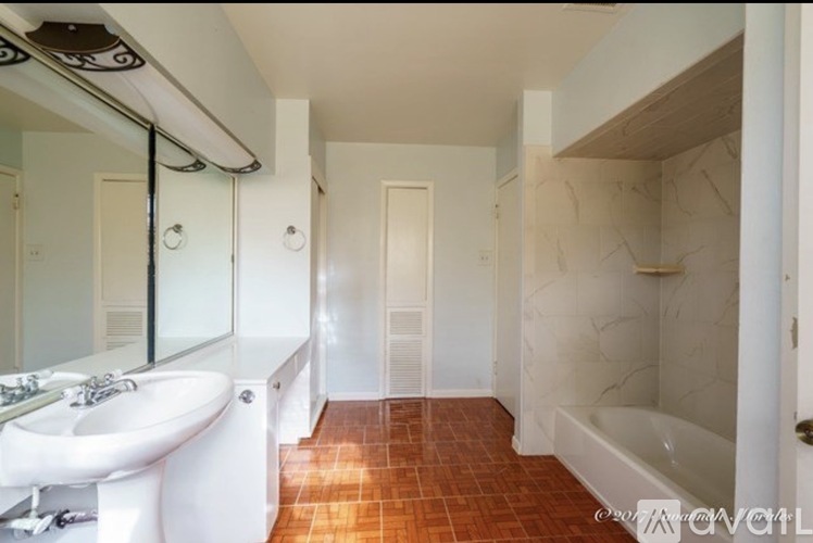 A bathroom with a white sink and a white toilet.