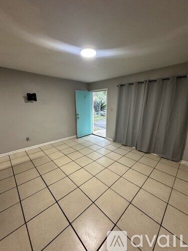 A room with a tiled floor and a door leading outside.