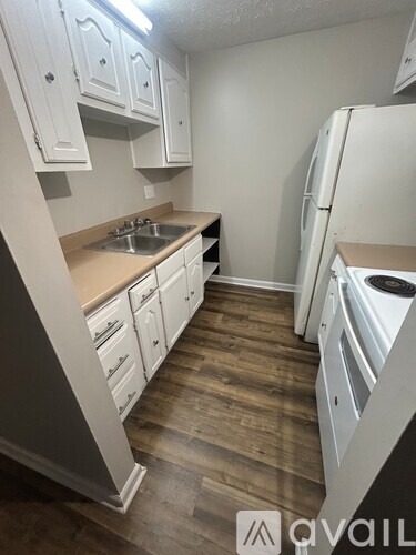 A kitchen with white cabinets and a wooden floor.