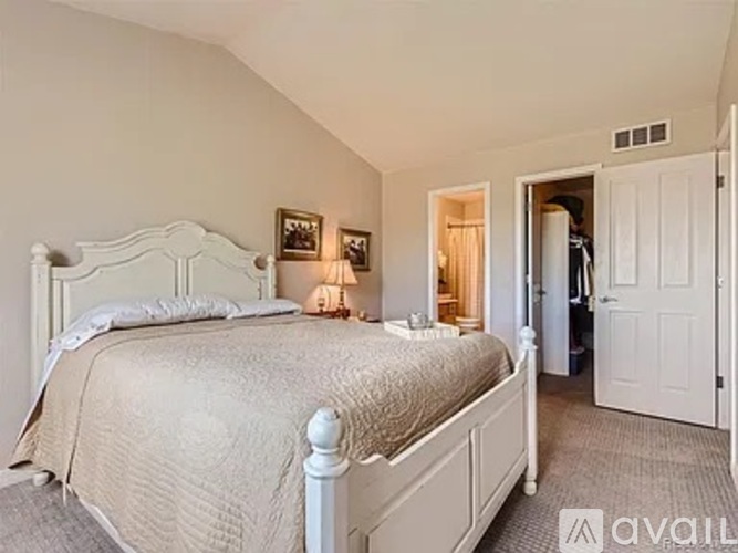 A bedroom with a large bed and a carpeted floor.