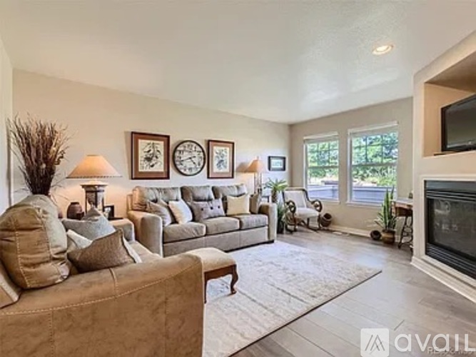 A living room with a couch, a chair, a fireplace, and a television.