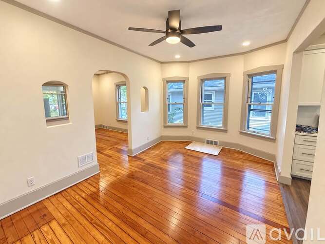 A room with wooden floors and a ceiling fan.