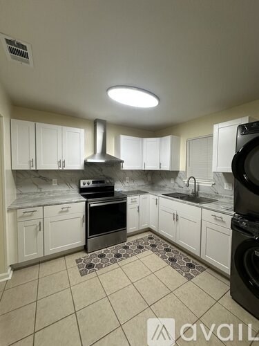 A kitchen with white cabinets and a black stove top oven.