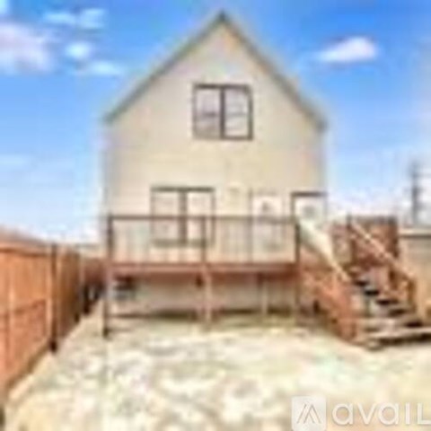 A house with a wooden deck and a fence.