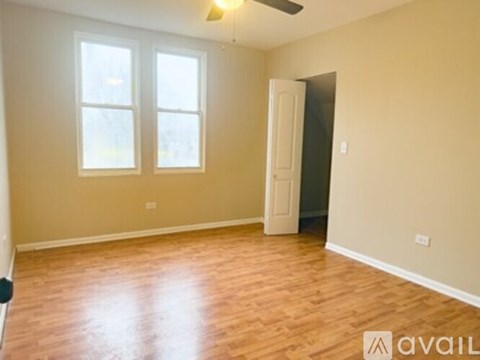 A room with wooden flooring and a ceiling fan.