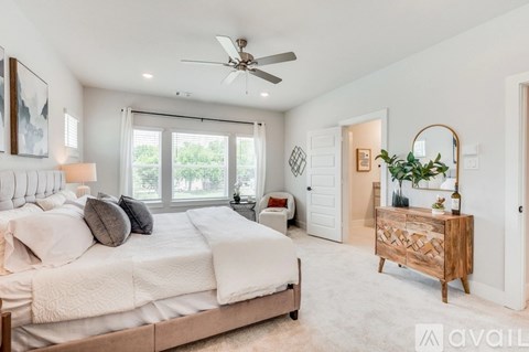 A bedroom with a large bed and a ceiling fan.