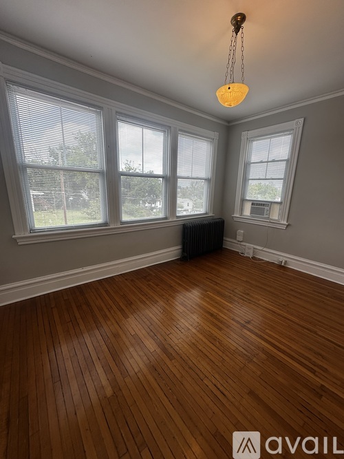 A room with wooden floors and a hanging light fixture.