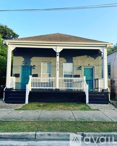 A two-story house with a front porch and a brown roof.