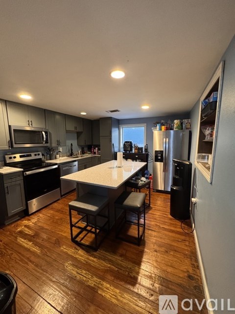 A kitchen with wooden floors and a large island in the middle.