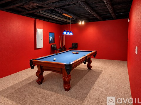 A pool table in a room with red walls.