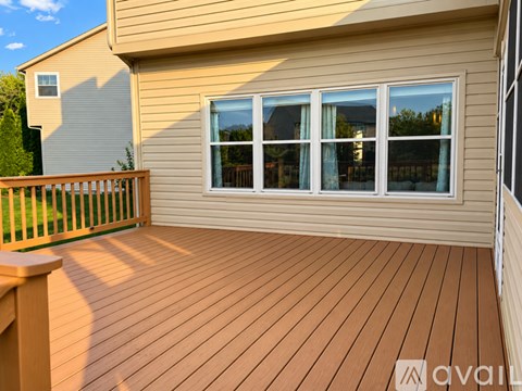 A wooden deck with a railing and a window.