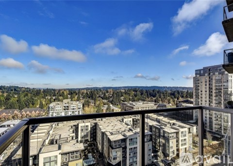 A view from a balcony overlooking a cityscape with buildings and trees.