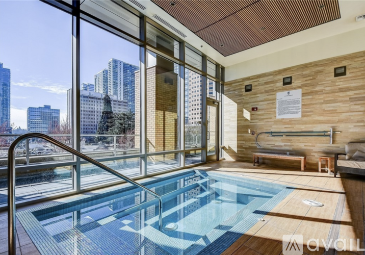 A large indoor swimming pool with a view of the city outside the windows.