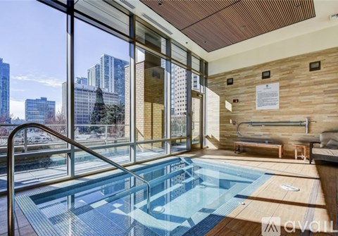 A large indoor swimming pool with a view of the city outside the windows.