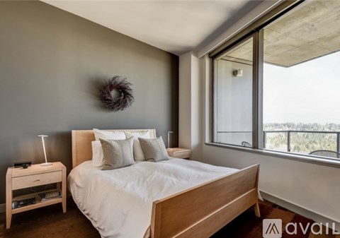 A bedroom with a large bed and a window overlooking the outdoors.