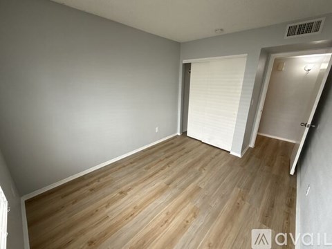 A room with wooden flooring and white walls.